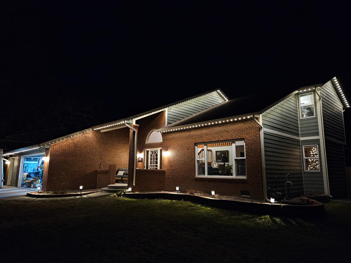 Warm white RGBW roofline on brick home at night