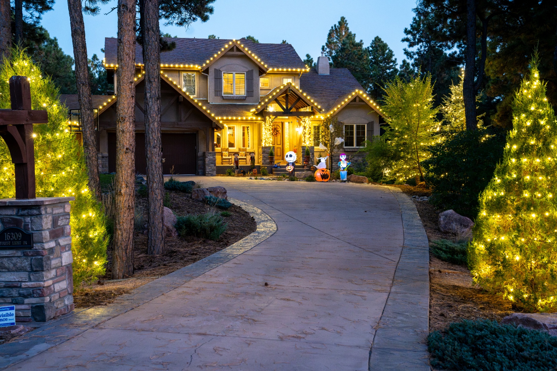 Same home at dusk with AFTERGLO seasonal Christmas lights installed on the roofline and landscaping