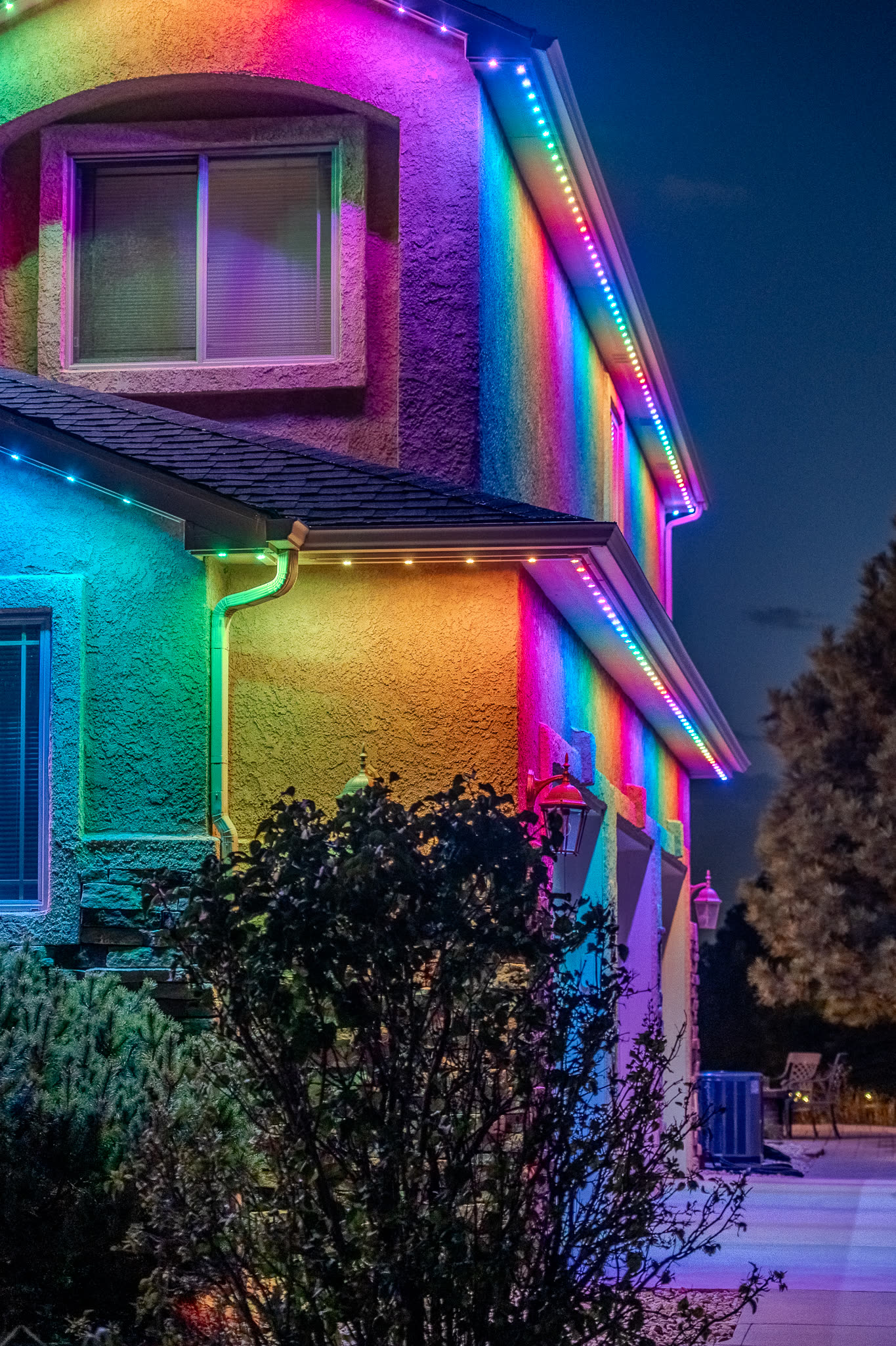 Home with rainbow colored permanent LED roofline lighting