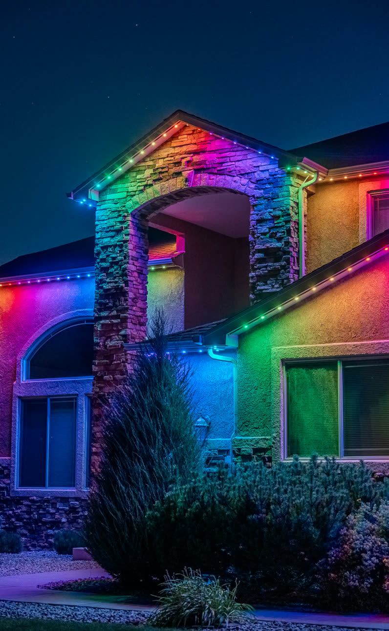 Home with rainbow colored permanent LED roofline lighting