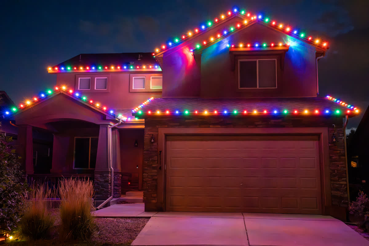 Home with multicolor Christmas string lights on the roofline