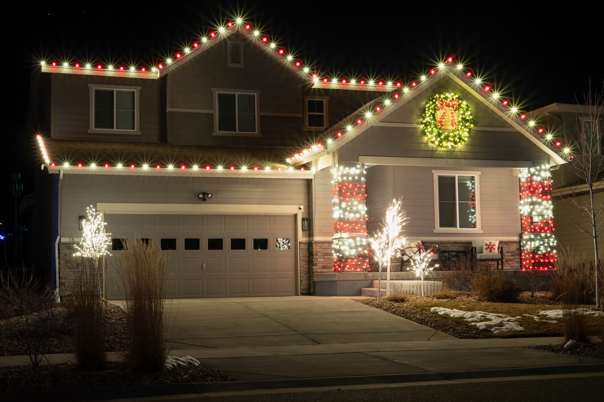 Wreath medallion and wrapped porch columns with Christmas string lights